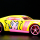 A photo of a Princess Peach-themed Hot Wheels car in pink and yellow.